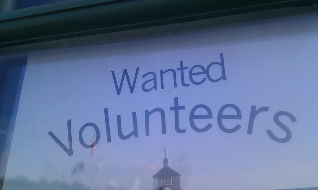 Sign in a window says, "Wanted: Volunteers." 