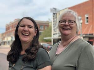 Becky McCray and Deb Brown with downtown buildings in the background