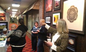 Frame shop owner Carolyn Murrow hosted a local photographer in her business's foyer during an evening art walk in Alva, Oklahoma. Photo by Becky McCray.