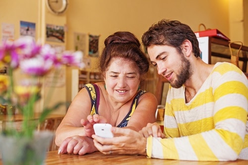 Young man helps abuela with a cell phone