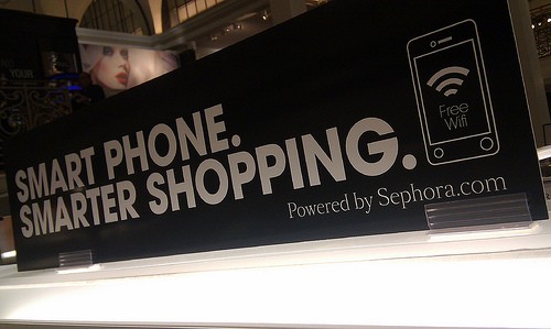 Sign in a retail store says, "Smart phone, smarter shopping. Free wifi."