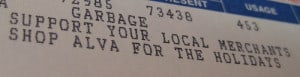 Utility bill printed with, "Garbage. Support your local merchants. Shop Alva for the holidays."