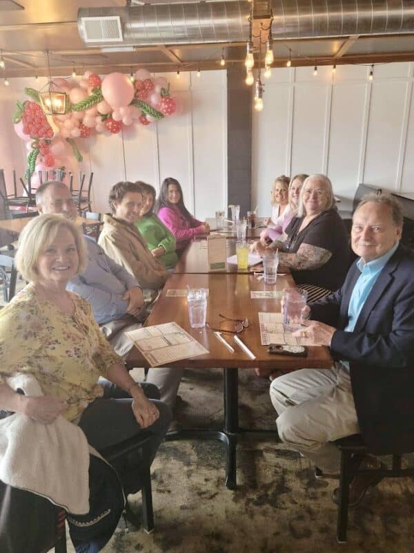 A group of smiling people around a dinner table