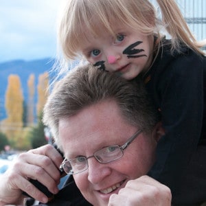 Mark Riffey carrying his little granddaughter on his shoulders