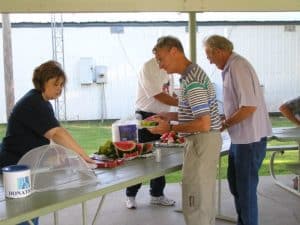 People moving along a picnic serving line