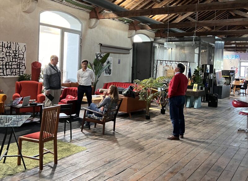 Several people preparing for a panel presentation in a coworking space in Portugal