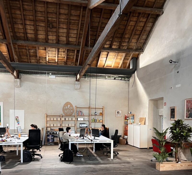 People working at open desks in a coworking space in Portugal