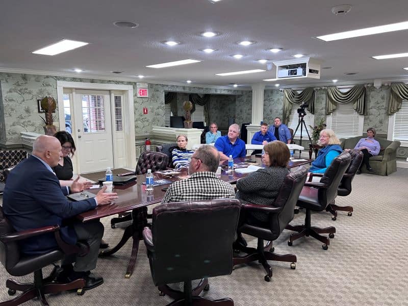 A group seated around a table in a meeting room