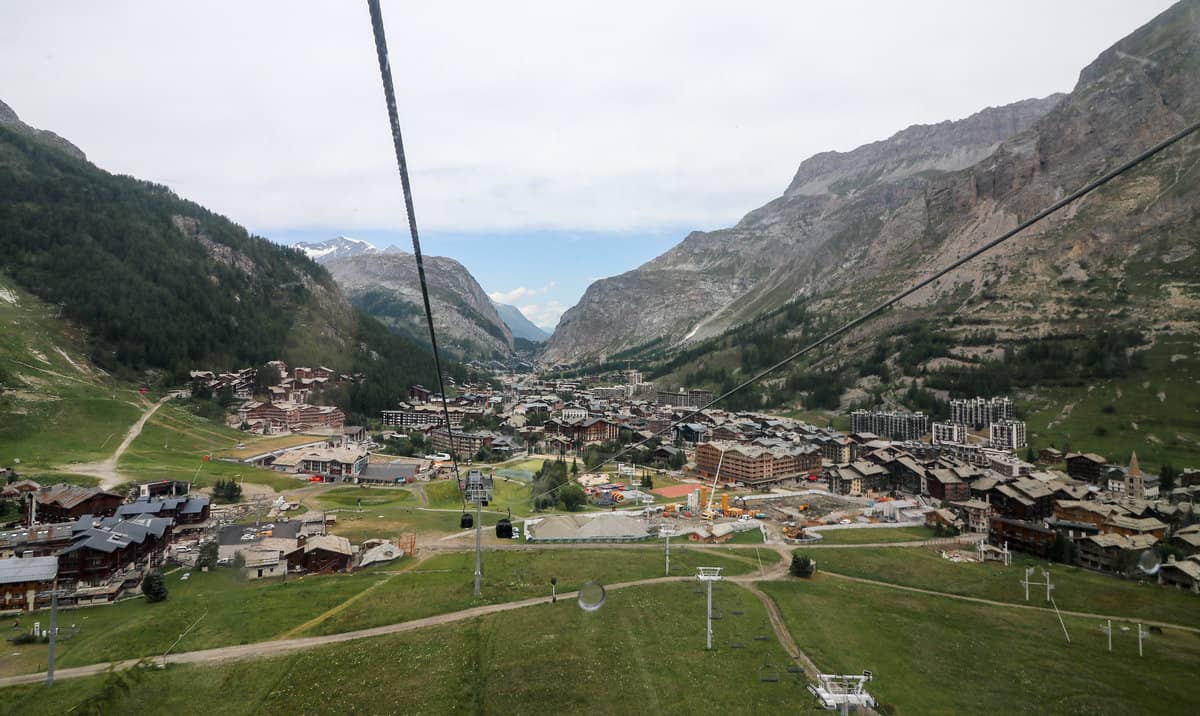 Looking down from a ski lift chair during summer, you see the whole ski town and resorts spread out in the green valley between two mountain ridges.