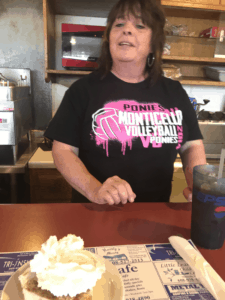 Woman posing with a piece of pie at her cafe